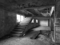 Staircase between floors in an empty messy industrial warehouse, urban exploration of the interior of an abandoned building, with Royalty Free Stock Photo