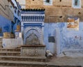 Staircase, fountain, baskets &tile painting in Chefchaouen, a city in northwest Morocco noted for its buildings in blue shades. Royalty Free Stock Photo