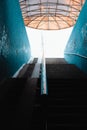 A staircase going up from a dark underground to the bright street