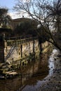 Staircase of a group of houses by the edge of a stream of water on a sunny day in the italian countryside