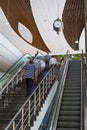 A staircase inside the railway station, visitors climb the stairs, a huge vintage clock is installed above the stairs.