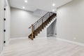 A staircase leading into an empty finished basement room.