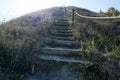 A staircase leading to a green hill. Old with wooden steps. Royalty Free Stock Photo