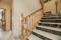 staircase with marble steps and beech wood railings inside an urban single-family residential house Royalty Free Stock Photo