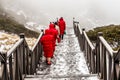 The staircase in the mountains and people in red clothes climbing to the Cang Mountains Cangshan near Dali city, China.