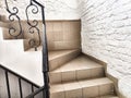 A staircase with stone steps, carved wrought iron railings and brick walls. Location, interior inside Royalty Free Stock Photo