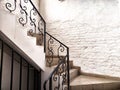 A staircase with stone steps, carved wrought iron railings and brick walls. Location, interior inside Royalty Free Stock Photo