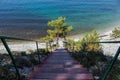 A staircase to the sea on the rocks leads to a wild beach. Road through the forest and camping Royalty Free Stock Photo