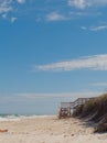 Stairs on a beach in central Florida with sunbather and people swimming. Serene beach scene with blue sky, sand and waves Royalty Free Stock Photo