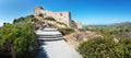 Stairs through bushes to ruins of medieval castle Kritinia with sea in backgraound Rhodes, Greece