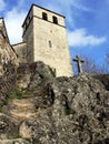 Stairs carved in rocks and stone cross before a bell tower