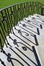 Stairs and curled wrought iron railing with shadows