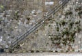 Stairs and iron railing along a stone wall Royalty Free Stock Photo