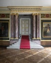 Stairs leading to a closed door surrounded by large marble columns Royalty Free Stock Photo