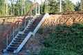 Stairs made of concrete and metal across the railway tracks. Crossing rails in forest and field Royalty Free Stock Photo