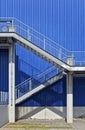 Stairs made of steel in front of blue metal wall