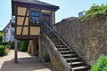 Stairs on an old stone wall with a small half-timbered house Royalty Free Stock Photo