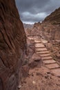 Stairs path in The ancient Nabatean city of Petra in Jordan, with view to a main road in street of facades