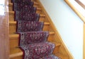 Stairs with red pattern carpet strip, old vintage wooden staircase, antique design Royalty Free Stock Photo