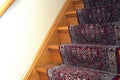 Stairs with red pattern carpet strip, old vintage wooden staircase, antique design Royalty Free Stock Photo