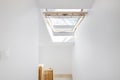 Stairs of a residential house with an attic with a tilt-and-turn skylight made of glass and wood