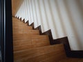 Stairs and the shadow of the banister... With wood-patterned ceramic textured doormats...