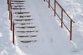 Stairs steps with metal railing covered with snow, winter background Royalty Free Stock Photo