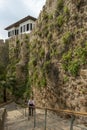 Stairs between stone walls with hanging ivy going down to an Antalya