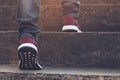 Stairway. Close up legs jeans and shoes sneakers red of young hipster man