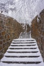 The stairway covered by snow and was braced by rock wall ,among with trees covered by snow Royalty Free Stock Photo