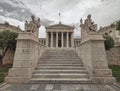 Stairway between Plato and Socrates statues in front of the national academy of Athens, Greece under an impressive cloudy sky