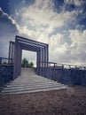 Stairway to heaven concept. Door to the sea on bright morning light on the sky. Outer staircase with wooden gate and fence. Royalty Free Stock Photo