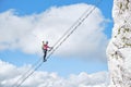 Stairway to heaven concept with a female climber holding her fist up and tight, on the via ferrata ladder