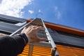 Stairway to Heaven. A man reaches out with his hand for a metal staircase in a building against the background of the sky and Royalty Free Stock Photo