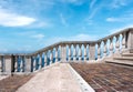 Stairway with white balustrade with seascape and blue sky with clouds