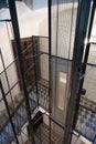 Stairwell looking into an elevator shaft with metal rods, cables and cabin in a vintage apartment building Royalty Free Stock Photo