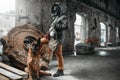 Stalker in gas mask and dog in ruins, survivors