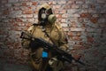 Stalker in gas mask with weapon near the brick wall Royalty Free Stock Photo