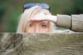 Stalking woman behind a fence hiding her face Royalty Free Stock Photo