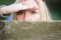 Stalking woman behind a fence hiding her face Royalty Free Stock Photo