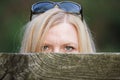 Stalking woman behind a fence hiding her face Royalty Free Stock Photo