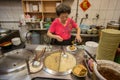 Stall vendor woman prepares taiwanese noodles for sale at her stall