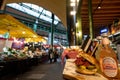 Stalls at Borough Market in east London UK with wide range of food stalls. Salt beef sandwich and Fentimans lemonade in foreground