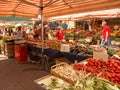 Stalls with fruit and vegetable boxes and customers watching