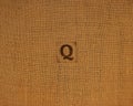 Stamp letters on linen fabric. Letter Q.