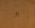 Stamp letters on linen fabric. Letter U.