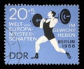 Stamp printed in GDR shows weightlifter