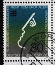 A stamp printed in Germany showing a stylized face and a cross symbol, Not by Bread alone, 15th meeting of German Protestants Royalty Free Stock Photo