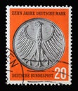 Stamp printed in Germany shows Heraldic Eagle 5 mark coin, 10th anniversary of the German currency reform