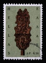 Stamp printed in Greece shows Wooden distaff with Saints George and Barbara